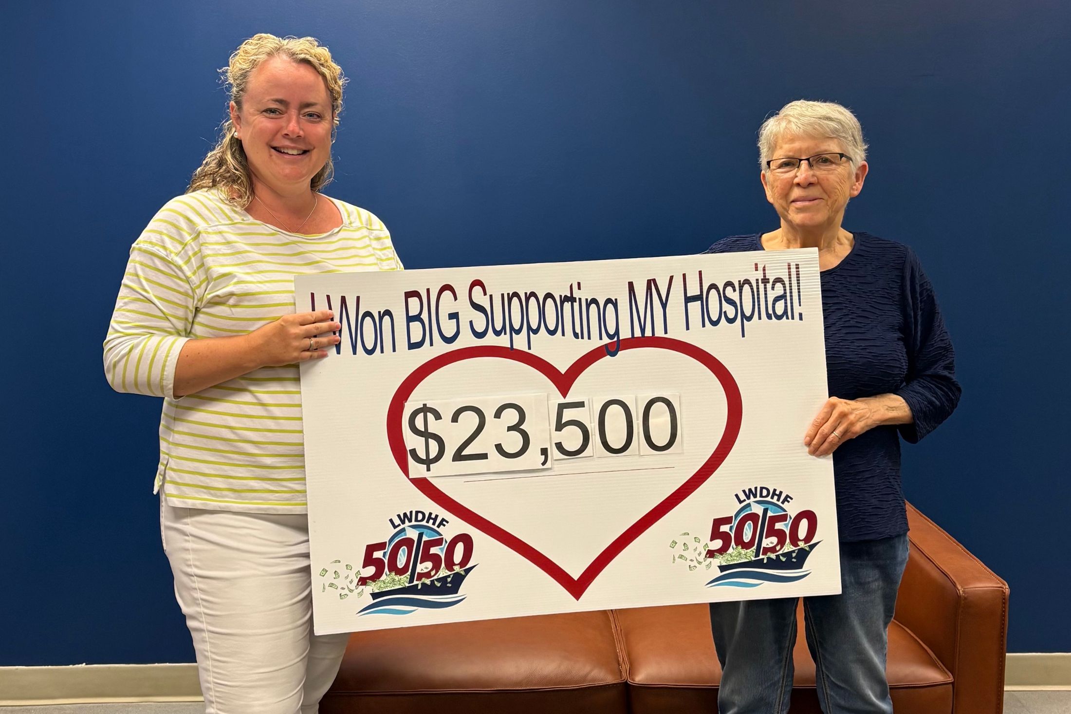 Charlotte McDonald accepts her winnings from the June 50/50 Jackpot.